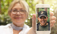 Woman holding phone with picture of Veteran