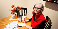 Woman sitting at a table writing in cards